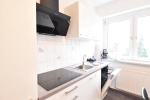 a white kitchen with a sink and a window at CoreRooms - Apartment Bochum Wattenscheid in Bochum