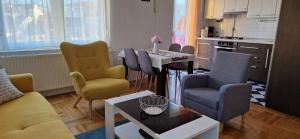 uma sala de estar com cadeiras e uma mesa e uma cozinha em CENTRUM with private parking em Virovitica
