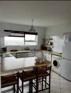 una cucina con tavolo e alcune sedie di B1001 Ocean View a Bloubergstrand