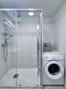 une machine à laver dans une salle de bain avec douche dans l'établissement Apartamento-Estudio en la Playa, à Patalavaca