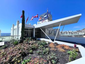 un bâtiment avec un jardin en face dans l'établissement Apartamento-Estudio en la Playa, à Patalavaca