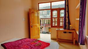 a bedroom with a bed and a window and a desk at Sweet Dreams in Dharamshala