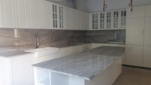 a kitchen with white cabinets and a marble counter top at Royal Course Villa, Vale do Lobo in Vale do Lobo