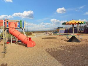 un parque infantil vacío con tobogán y sombrilla en Holiday home Bogense XLV, en Bogense