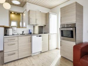 una cocina con armarios de madera y electrodomésticos blancos en Holiday home Bogense XLV, en Bogense
