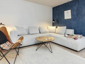 Holiday home Faaborg XXVII في فابورغ: غرفة معيشة مع أريكة بيضاء وطاولة