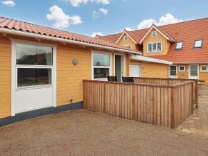 una casa con una valla de madera delante de ella en Holiday home Bogense XLVII, en Bogense