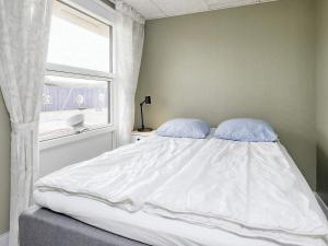 1 cama con 2 almohadas en un dormitorio con ventana en Holiday home Bogense XLVII, en Bogense