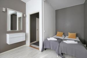 een slaapkamer met twee bedden en een spiegel bij Kotimaailma Apartments Kamppi - studio for 2 in Helsinki