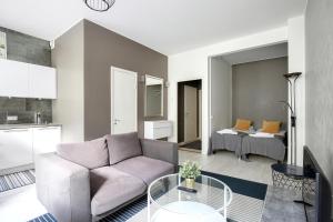een woonkamer met een bank en een bed bij Kotimaailma Apartments Kamppi - studio for 2 in Helsinki