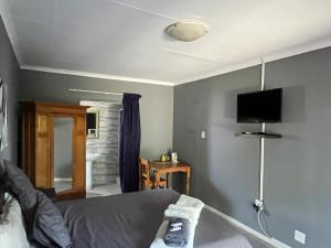 a bedroom with a bed and a tv on the wall at Balfour Lodge in Balfour