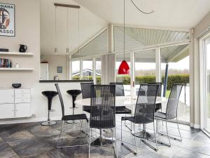 a dining room with a table and black chairs at Holiday home Sydals XCIX in Neder Lysabild