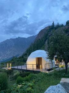 a tent in a field with mountains in the background at SG Glamping Resort in Hunza