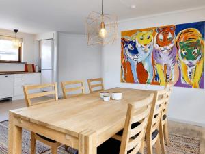 a dining room table with chairs and a painting on the wall at Holiday home Skagen XXXVI in Skagen