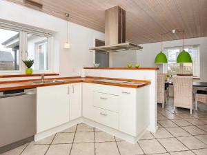 uma cozinha com armários brancos e uma bancada em Holiday home Ørsted V em Ørsted