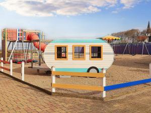 una casa pequeña sentada en un banco en un patio de juegos en Holiday home Bogense XLVIII en Bogense