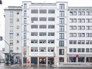 un bâtiment blanc au coin d'une rue dans l'établissement numa I Leo Apartments, à Düsseldorf