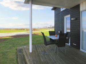 eine Terrasse mit einem Tisch und Stühlen auf einer Veranda in der Unterkunft Holiday home Bogense XLVIII in Bogense