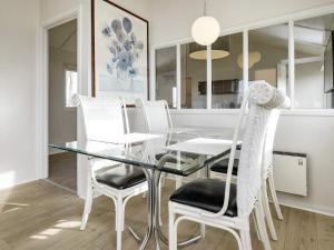 comedor con mesa de cristal y sillas blancas en Holiday home Bogense XLVI, en Bogense