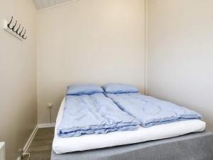 Una cama en una habitación con almohadas azules. en Holiday home Bogense XLVI, en Bogense