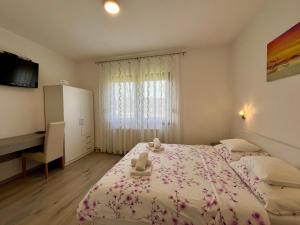 a bedroom with two beds and a desk and a window at House Turkalj in Grabovac