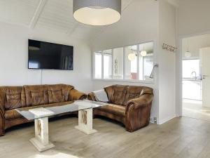 sala de estar con sofá de cuero y mesa en Holiday home Bogense XLVI en Bogense