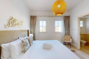 a bedroom with a large white bed and a chandelier at The Springs - Tranquil Two Bedroom Villa in Dubai