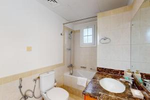 a bathroom with a toilet and a sink and a tub at The Springs - Tranquil Two Bedroom Villa in Dubai