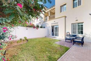 a backyard with two benches and a fence at The Springs - Tranquil Two Bedroom Villa in Dubai