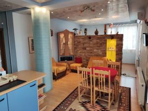 cocina y sala de estar con mesa y sillas en Rila Apartment, en Samokov