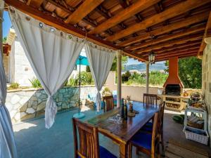 a dining room with a wooden table and a kitchen at Dubrovnik Chalets in Čilipi