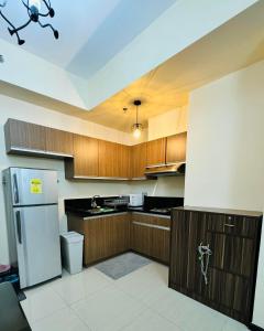 a kitchen with wooden cabinets and a white refrigerator at City Homes: The Radiance Manila Bay in Manila