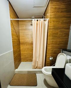 a bathroom with a shower curtain and a toilet at City Homes: The Radiance Manila Bay in Manila