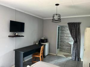 a room with a desk and a television on the wall at Balfour Lodge in Balfour