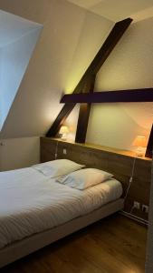 - un lit dans une chambre avec un toit dans l'établissement Le Relais de la Sans Fond, à Fénay