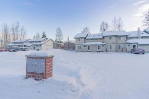 a snow covered parking lot with houses in the background at Alaska Daydream Retreat Near Downtown in Fairbanks