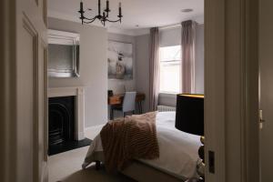 巴斯的住宿－Cambridge House，一间卧室配有一张床和一个壁炉