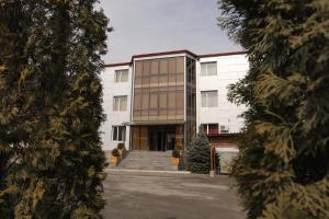 KapanSyunik Hotel的一座白色的大建筑,拥有玻璃幕墙