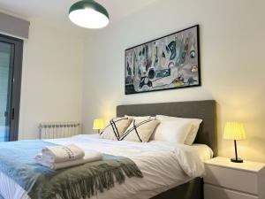a bedroom with a bed and a painting on the wall at Luxurious 3BR Green Getaway in Louaize 