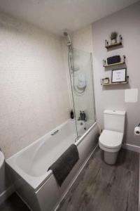 a bathroom with a tub and a toilet and a sink at City Retreat by the Castle Free Designated Parking in Stirling