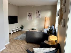 - un salon avec un canapé et une télévision dans l'établissement Modern Central Apartment Apt 105, à Stavanger
