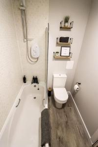 a bathroom with a white tub and a toilet at City Retreat by the Castle Free Designated Parking in Stirling