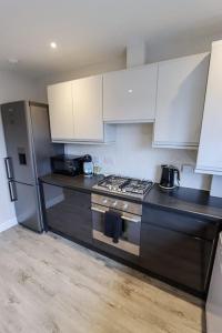 a kitchen with a stove and a refrigerator at City Retreat by the Castle Free Designated Parking in Stirling