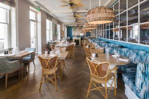 a restaurant with tables and couches and chairs at Harbour Hotel Fowey in Fowey