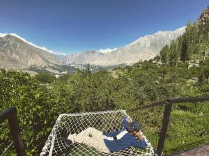 a man laying in a hammock on a mountain at SG Glamping Resort in Hunza
