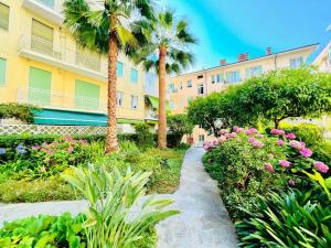 サンレモにあるSuite Vallarino 2 - Sanremoの建物前のヤシの木と花の庭園