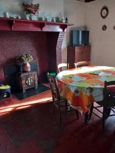 a dining room with a table and a fireplace at Maison de campagne Les Chênes. in Panjas