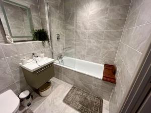 ein Badezimmer mit einem Waschbecken, einer Badewanne und einem WC in der Unterkunft Poole Quay Getaway in Poole