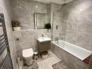 ein Badezimmer mit einem WC, einem Waschbecken und einer Badewanne in der Unterkunft Poole Quay Getaway in Poole