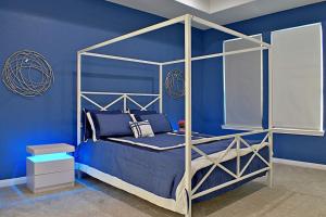 a blue bedroom with a canopy bed with blue walls at Stunning 6 Bedroom Near Downtown in San Antonio